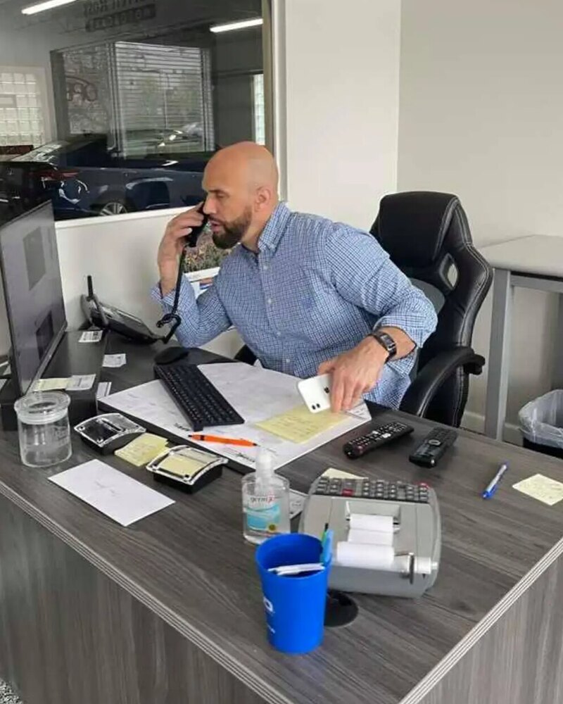 Cane Jackson at his desk at the dealership, taking a call